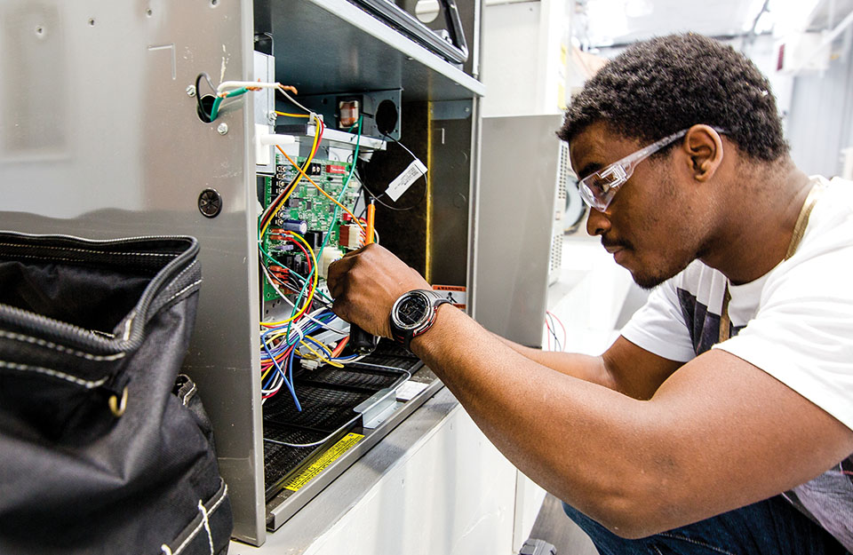 HVAC student becoming acquainted with an air conditioner unit in the Heating, Ventilation, &amp; Air Conditioning trades class at Central Tech Sapulpa campus.