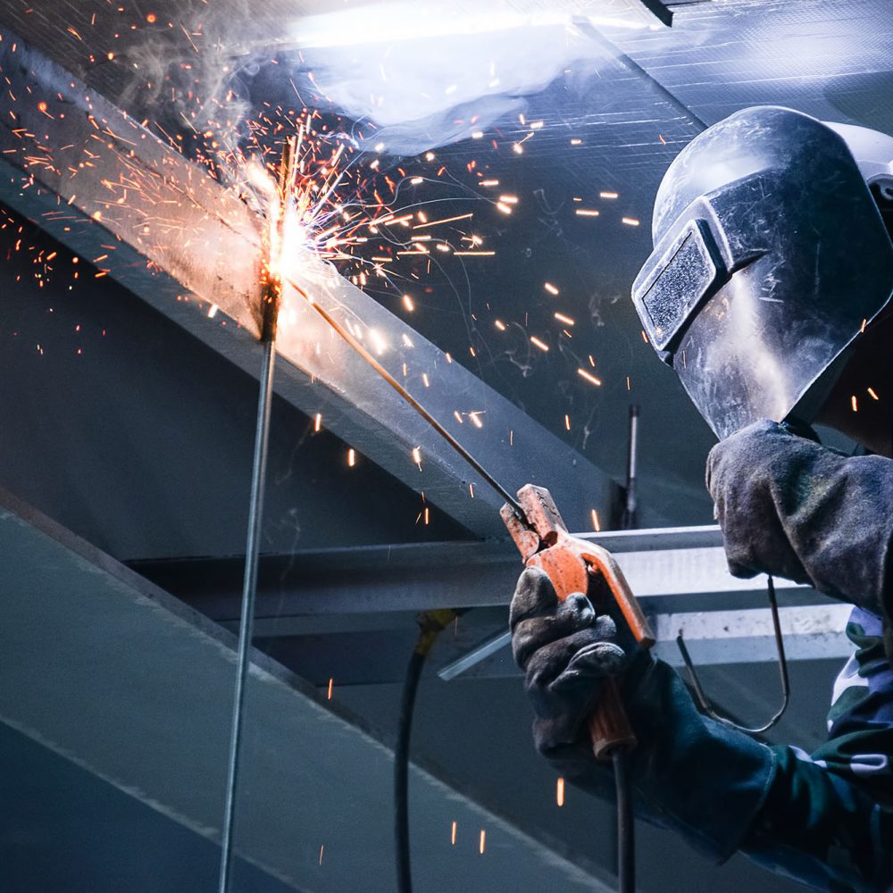 photo of person welding in a high space