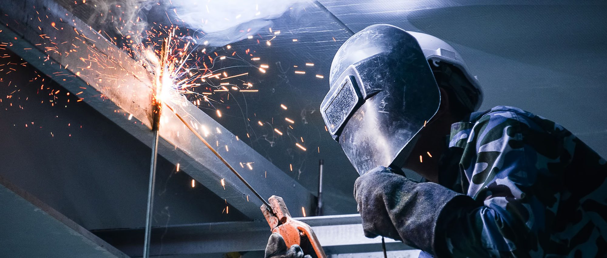 photo of person welding in a high space