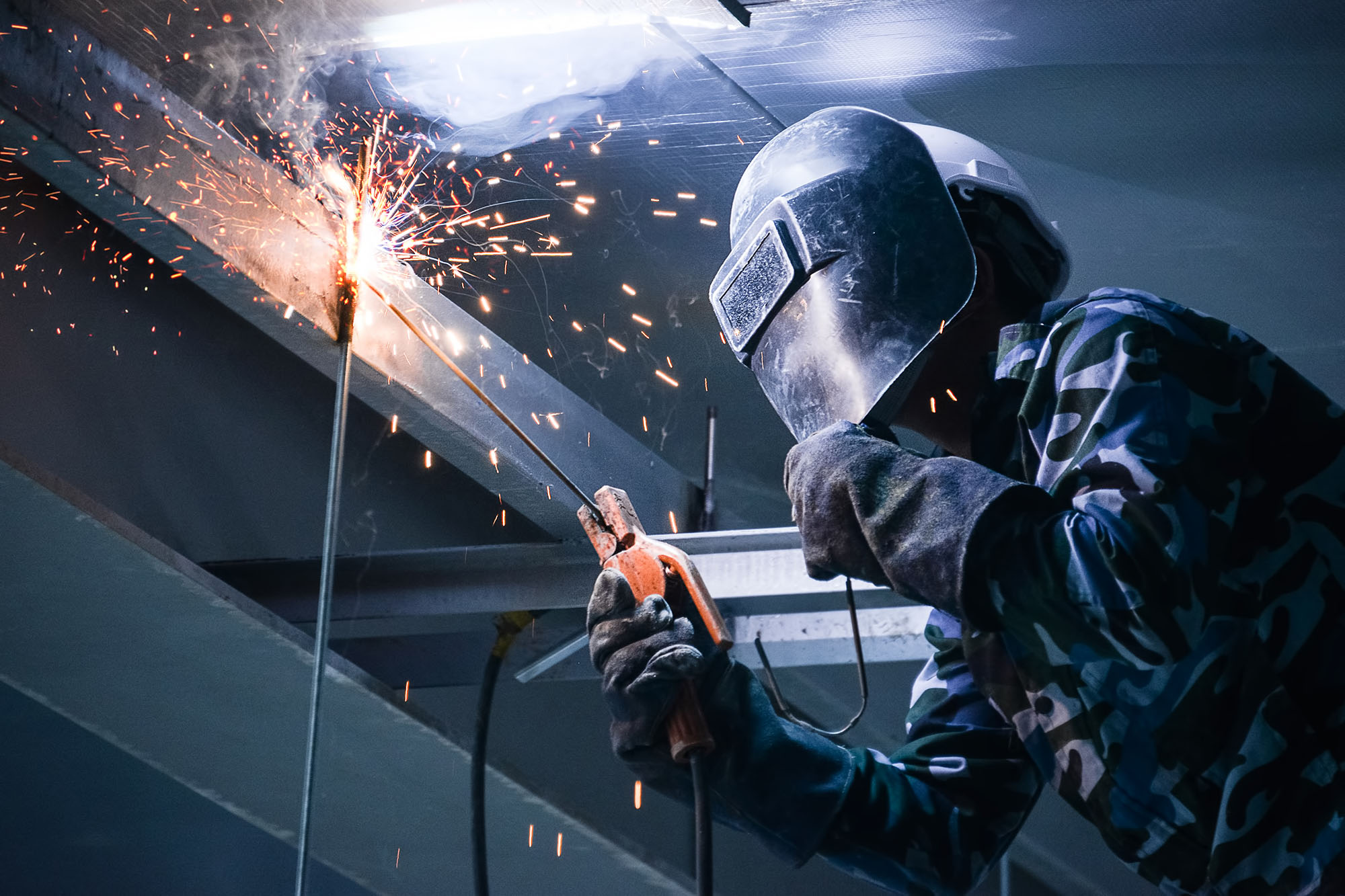 photo of person welding in a high space