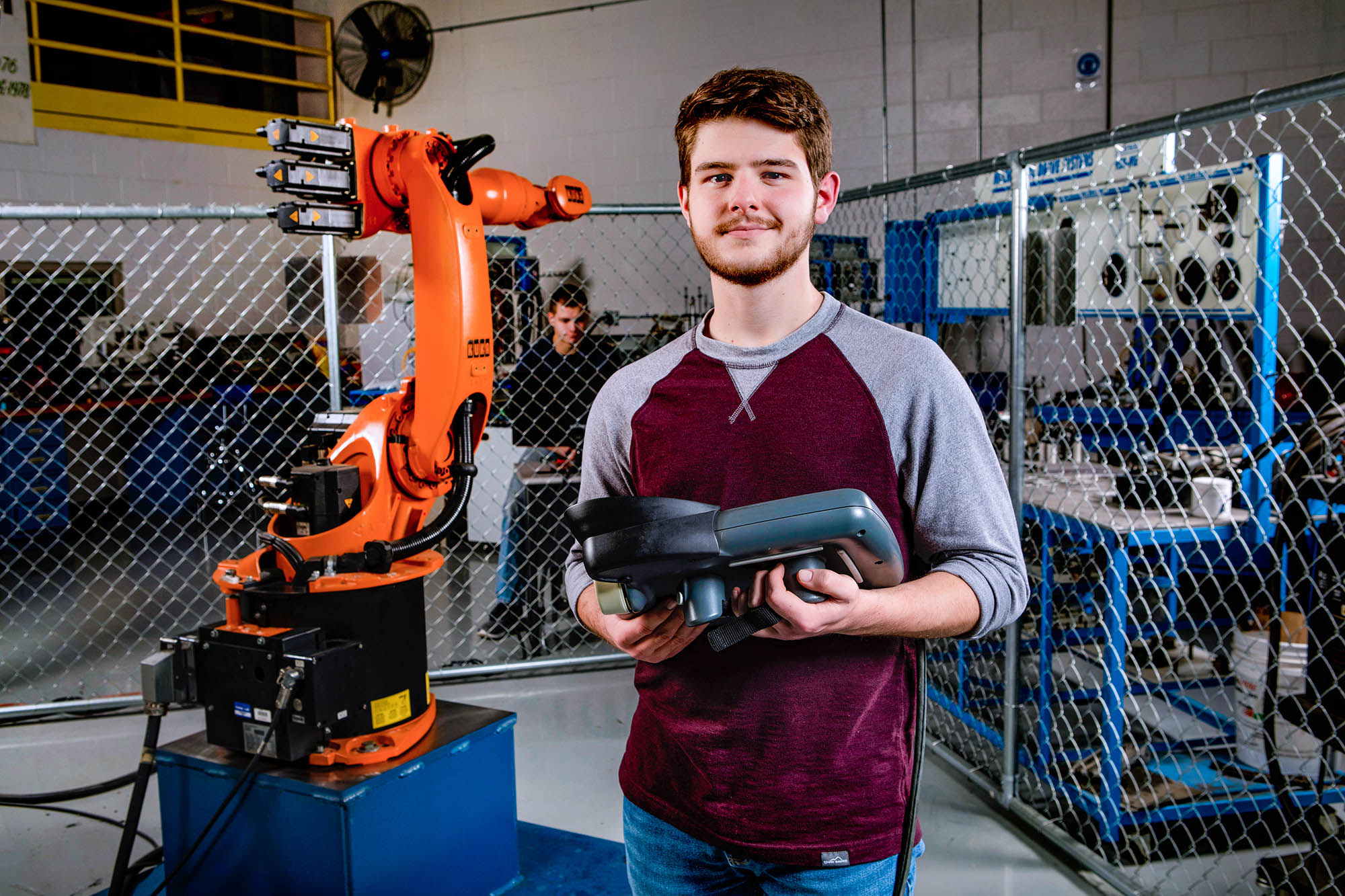 teen boy operating an electromechanical arm