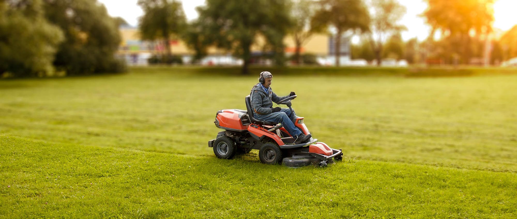 photo of a man driving a lawn mower