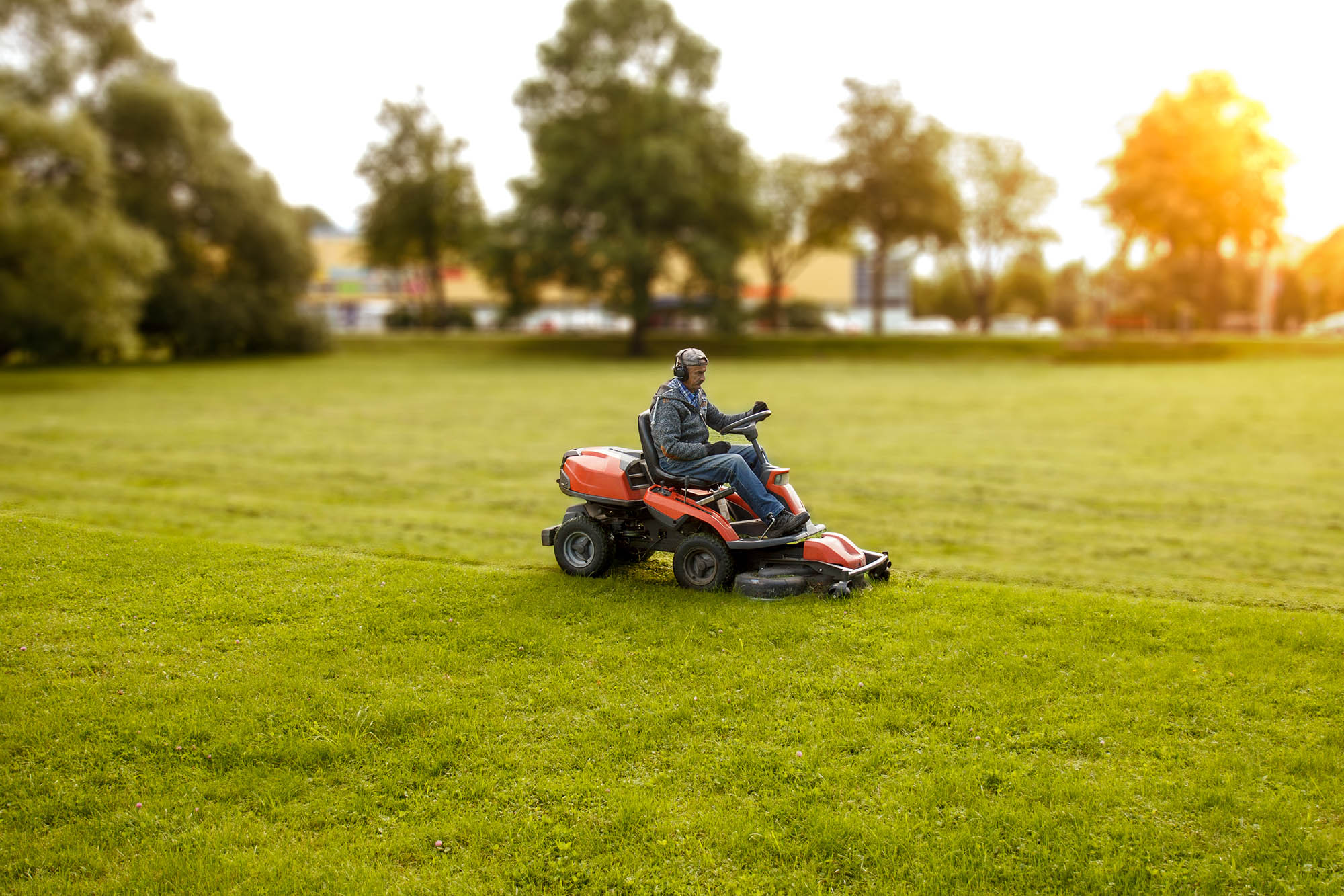 photo of a man driving a lawn mower