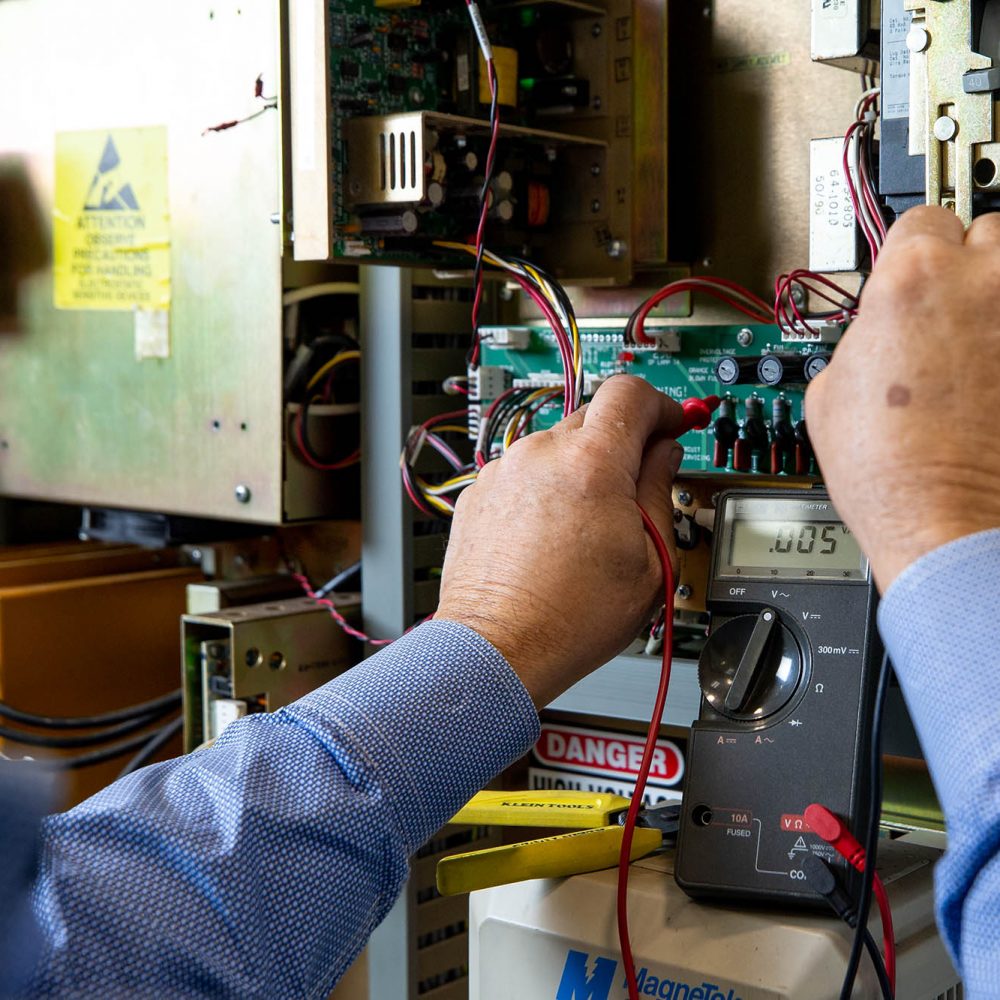 picture of an industrial maintenance technician using an ohm meter