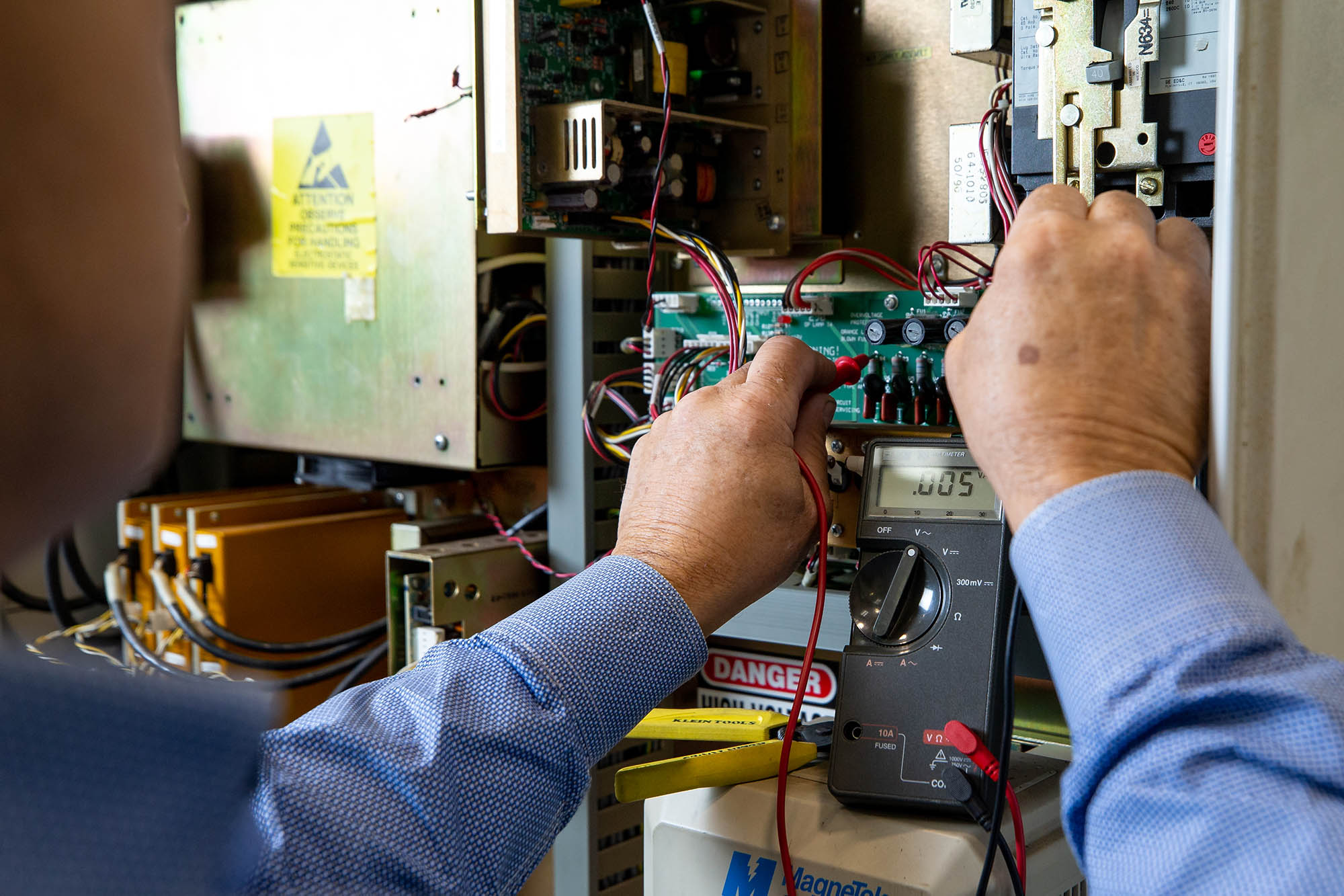 picture of an industrial maintenance technician using an ohm meter