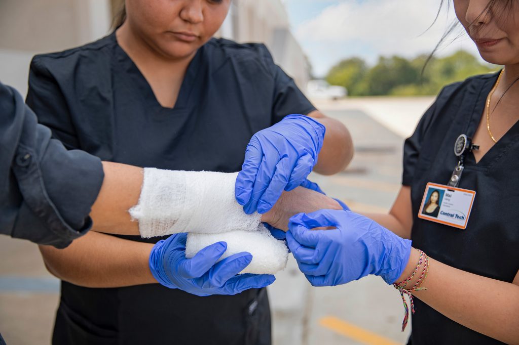 Health Careers students wrapping an injured arm in a bandage