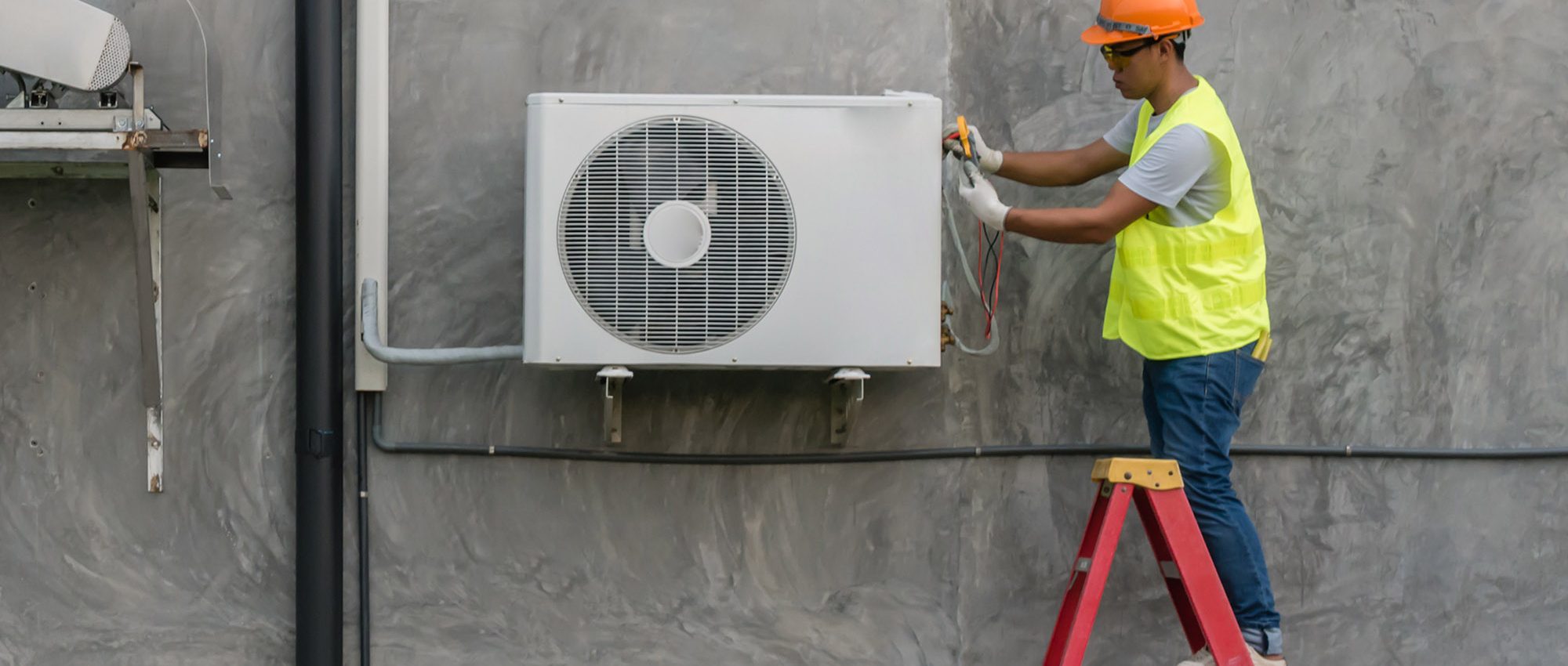 picture of an HVAC Technician checking an AC unit outside