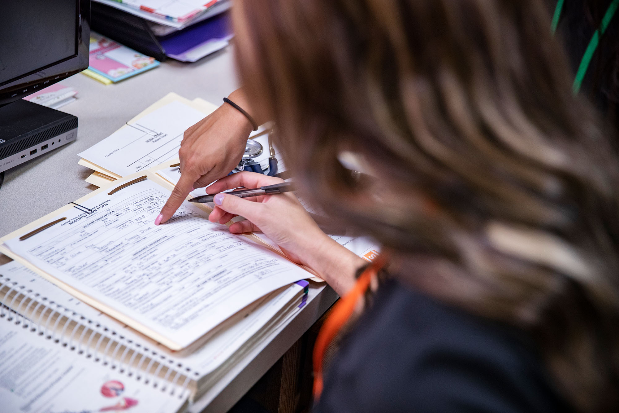 two medical administrative assistants looking at a patient chart