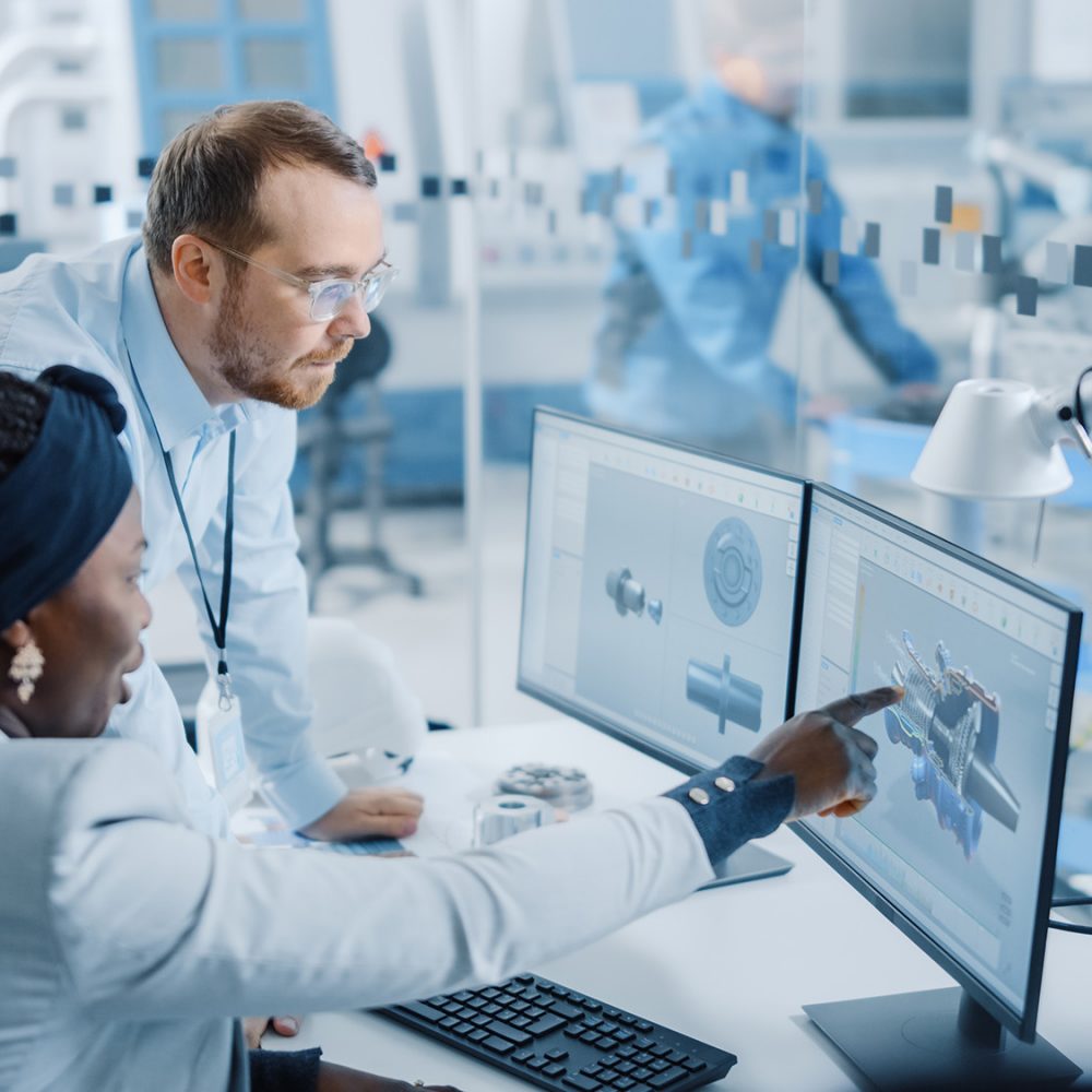 two people working on CAD in a manufacturing facility