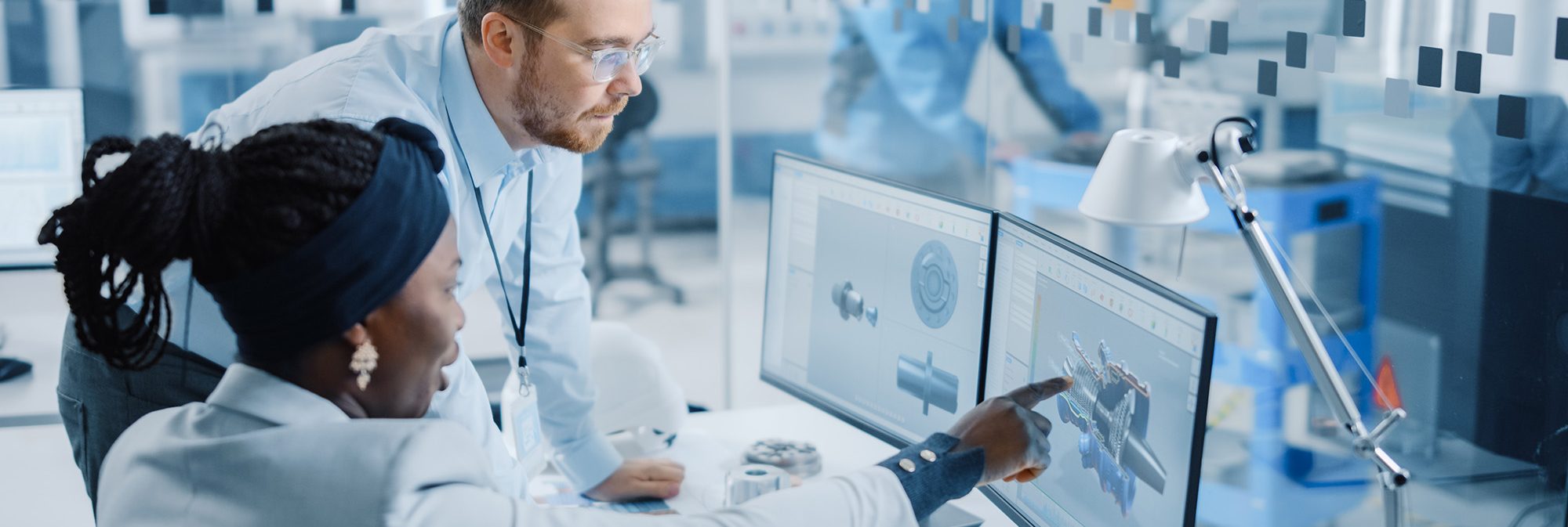 two people working on CAD in a manufacturing facility