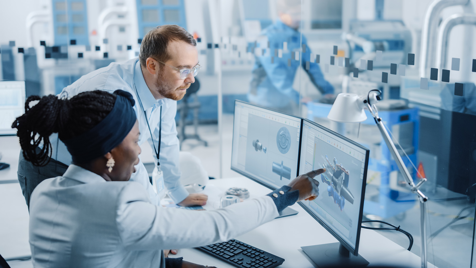 two people working on CAD in a manufacturing facility