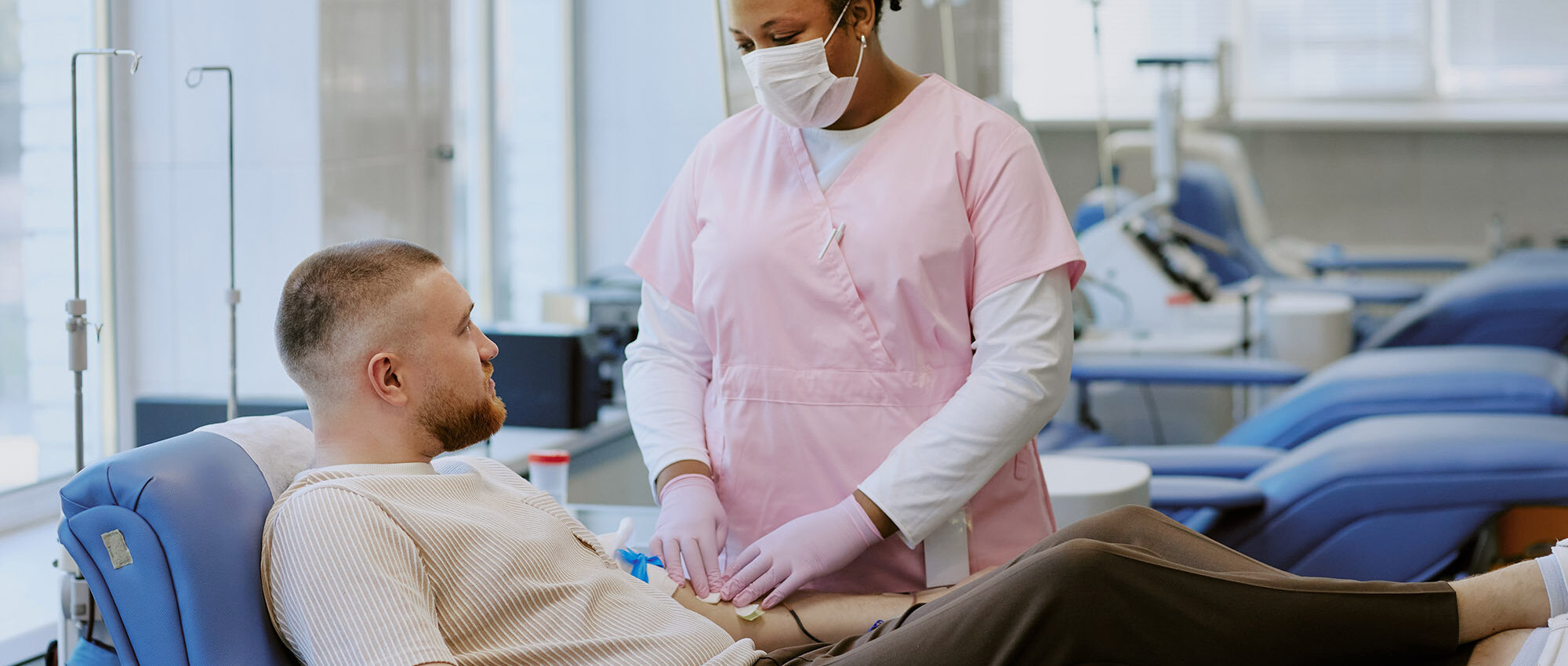 phlebotomist drawing blood from man