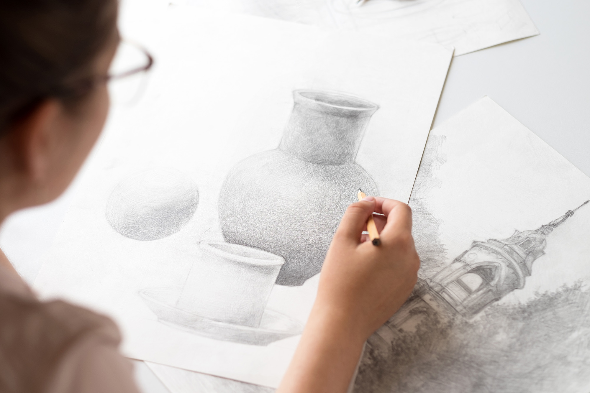 woman drawing still life object with pencil